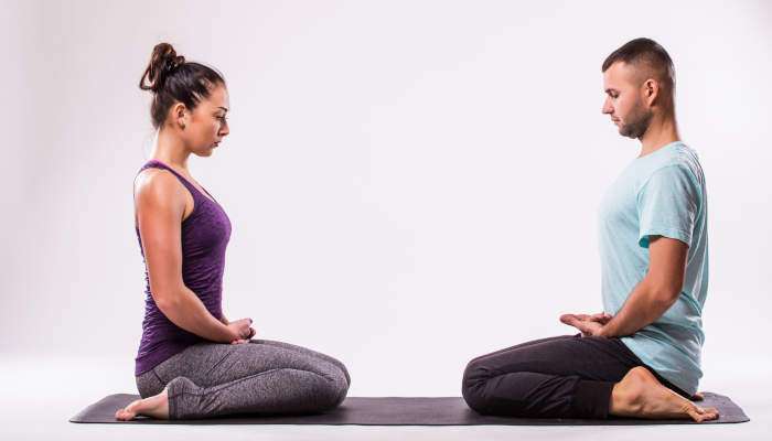 Young,healthy,couple,in,yoga,position,on,white,background