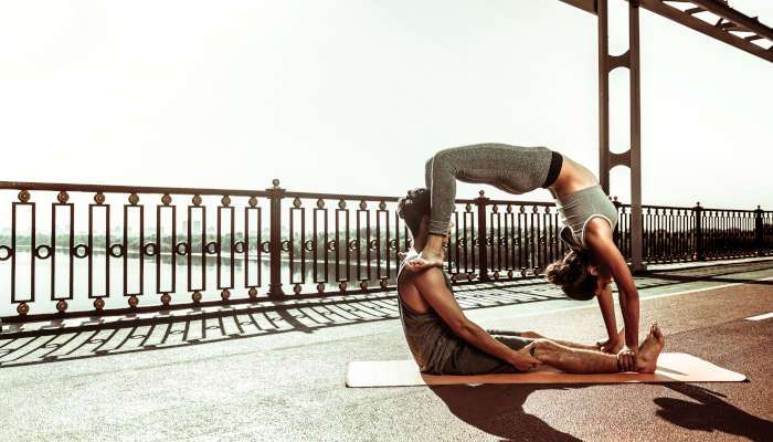 Couple,practicing,asanas.,slim,young,woman,standing,in,a,wheel